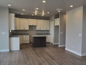 Kitchen featuring a sink, white cabinetry, baseboards, ceiling fan, and recessed lighting
