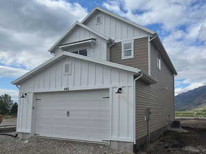 Garage with gravel driveway and a mountain view