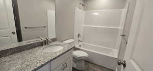Bathroom featuring toilet, vanity, and shower / bathtub combination