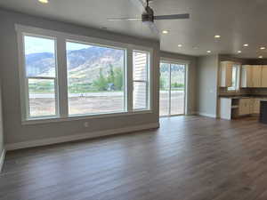 Unfurnished living room with ceiling fan, visible vents, baseboards, and a healthy amount of sunlight