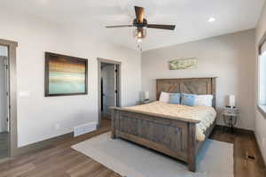 Bedroom with visible vents, baseboards, and wood finished floors