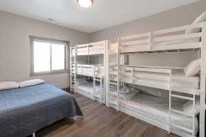 Bedroom with wood finished floors and visible vents