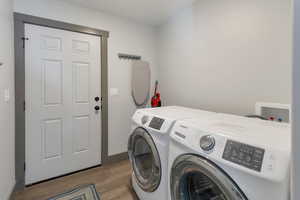 Washroom featuring light wood-style floors, washing machine and dryer, and laundry area