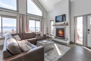 Living area featuring high vaulted ceiling, a glass covered fireplace, dark wood finished floors, and a mountain view