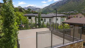 Back of house featuring a mountain view, driveway, and a patio area/bb court