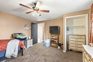 Carpeted bedroom featuring visible vents and a ceiling fan