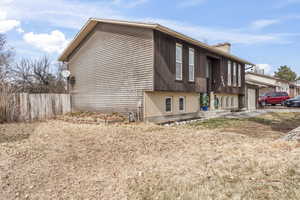 View of property exterior with a garage, a chimney, and fence