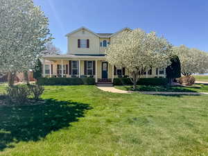 View of front of property with a porch and a front lawn