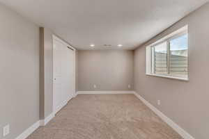 Carpeted spare room with recessed lighting, visible vents, and baseboards