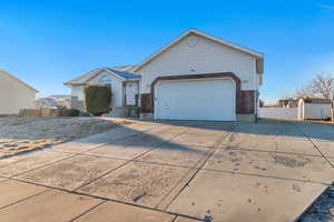 Ranch-style home with driveway, a garage, fence, and brick siding