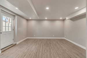 Basement with baseboards, wood finished floors, and recessed lighting