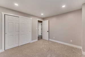 Unfurnished bedroom with carpet, a closet, baseboards, and recessed lighting