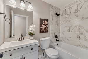 Bathroom featuring toilet, shower / tub combination, and vanity