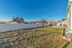 View of yard featuring an outbuilding, a fenced backyard, and a storage unit