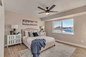 Bedroom featuring a ceiling fan, baseboards, and wood finished floors