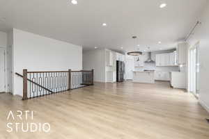 Unfurnished living room featuring light wood-type flooring, a sink, and recessed lighting