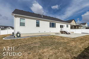 Rear view of house with a yard, fence, and a patio