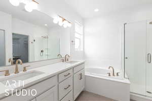 Bathroom with tile patterned flooring, a sink, a shower stall, and a bath