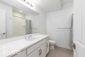 Full bath with baseboards, toilet, a shower with curtain, tile patterned flooring, and vanity