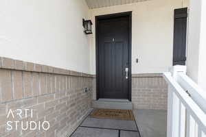 Property entrance with brick siding and stucco siding