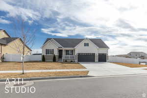 View of front of home with a garage, concrete driveway, stucco siding, and fence