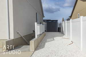 View of side of home featuring fence and stucco siding