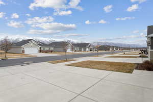 View of yard with driveway, a residential view, and a mountain view