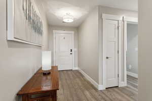 Doorway featuring baseboards and wood finished floors