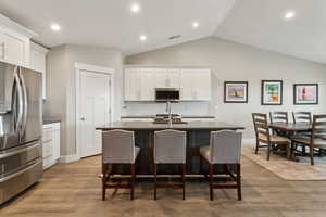 Kitchen with dark countertops, white cabinetry, visible vents, and stainless steel appliances