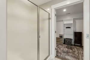 Bathroom with a shower stall, visible vents, and recessed lighting