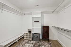 Walk in closet featuring visible vents and wood finished floors