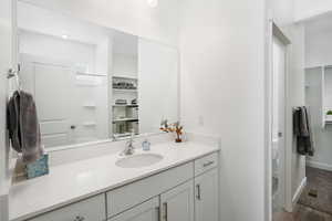 Full bathroom with baseboards, visible vents, and vanity