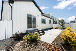 Back of property featuring a fenced backyard, board and batten siding, and a patio