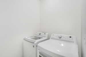 Clothes washing area featuring laundry area and washer and clothes dryer