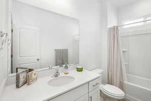 Full bathroom featuring shower / tub combo, vanity, and toilet