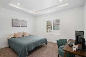 Bedroom with carpet floors, recessed lighting, a raised ceiling, and baseboards