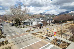 View of road with a residential view, curbs, traffic signs, sidewalks, and a mountain view