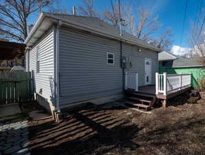 Back of property with fence and a wooden deck