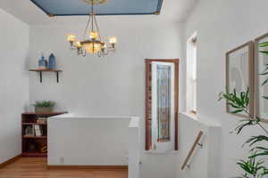 Interior space with an inviting chandelier, baseboards, and wood finished floors