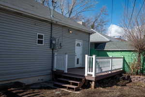 Exterior space featuring roof with shingles, a chimney, and a wooden deck