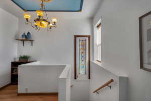 Interior space with a notable chandelier, baseboards, and wood finished floors