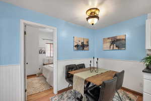 Dining area featuring a wainscoted wall and light wood finished floors