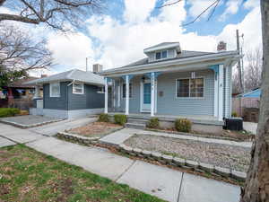 Bungalow-style house featuring covered porch, a chimney, fence, and central AC