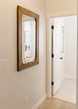 Hallway featuring wood finished floors and baseboards