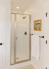 Full bathroom featuring recessed lighting and a shower stall