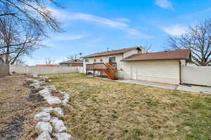 Back of house featuring a yard,  and a fenced backyard.