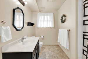 Bathroom with toilet, shower, a textured ceiling, and vanity