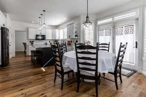 Dining area adjacent to kitchen and family room with doors to backyard.