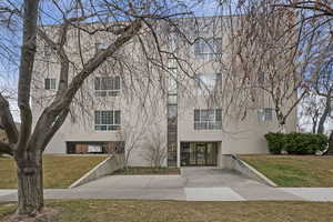 View of property featuring a front yard and stucco siding