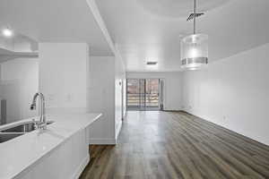 Kitchen with dark wood-style floors, a sink, visible vents, and pendant lighting